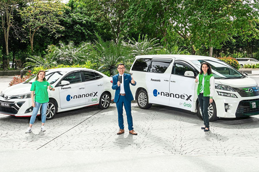 Panasonic Malaysia managing director Cheng Chee Chung (middle) flanked by the representatives from GrabAds (Malaysia) posing with GrabCar Premium vehicles equipped with nanoe X generators, at Grab Malaysia.